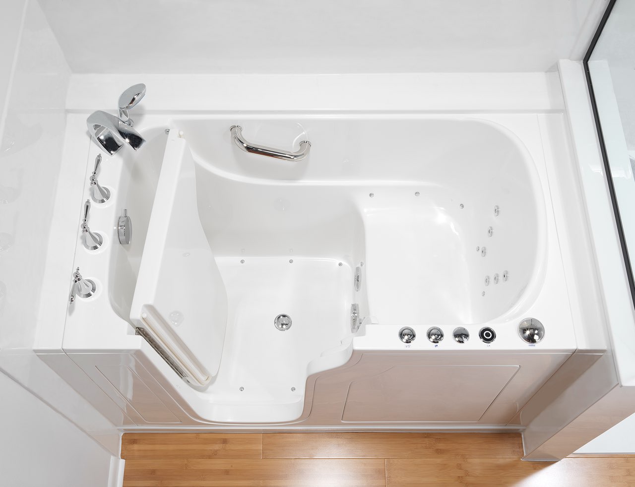 A walk-in tub with the door open, showing the low step-in, the built-in seat and the grab bar